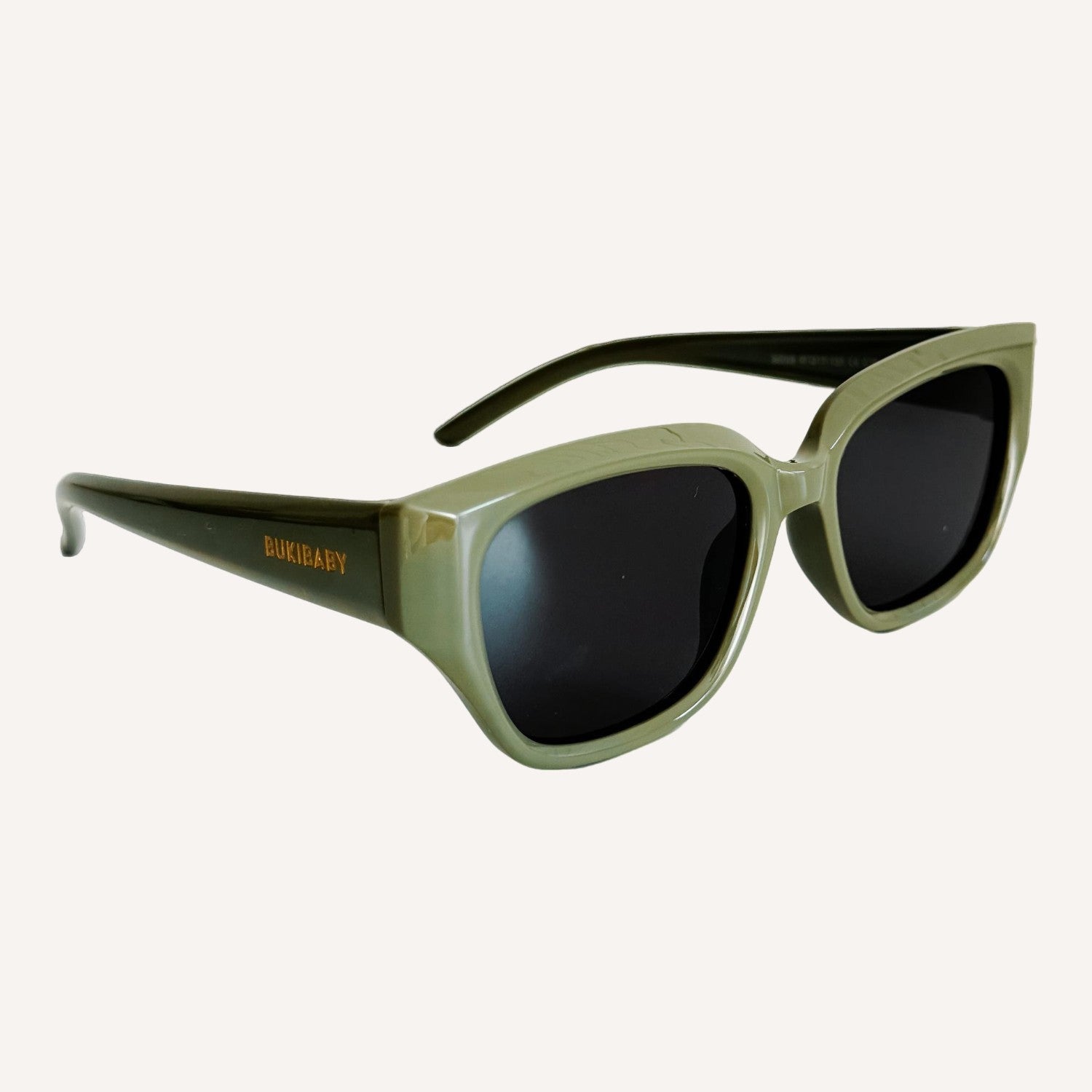 Green kids polarised sunglasses with dark lenses on a white background