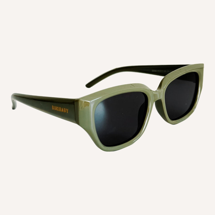 Green kids polarised sunglasses with dark lenses on a white background
