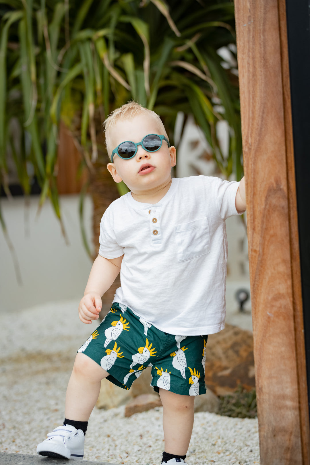 An adventuring toddler exploring the outdoors while wearing blue Bukibaby Sunglasses